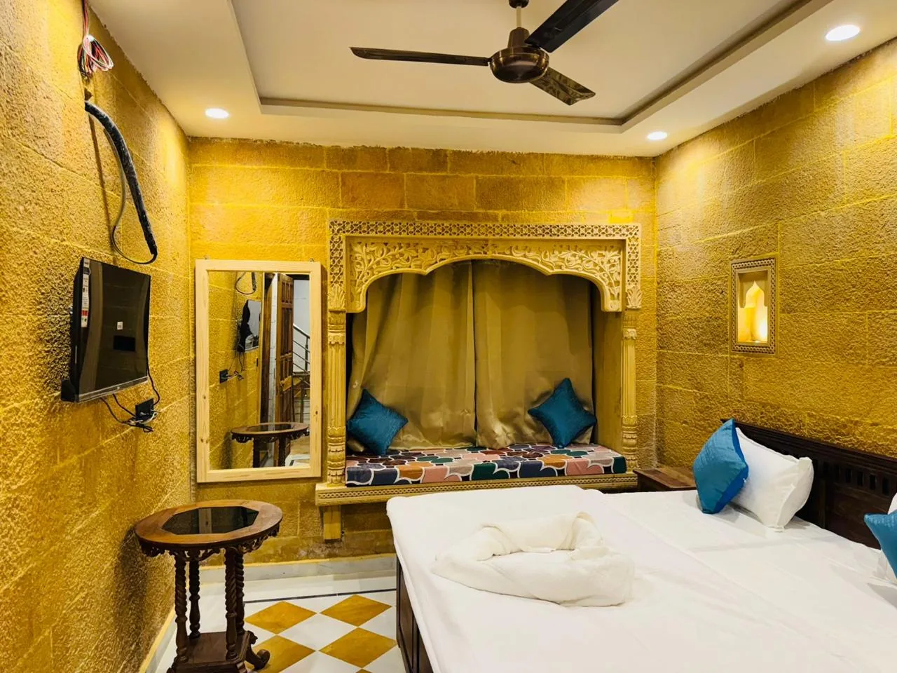 A carved sandstone alcove beside the bed in a deluxe room