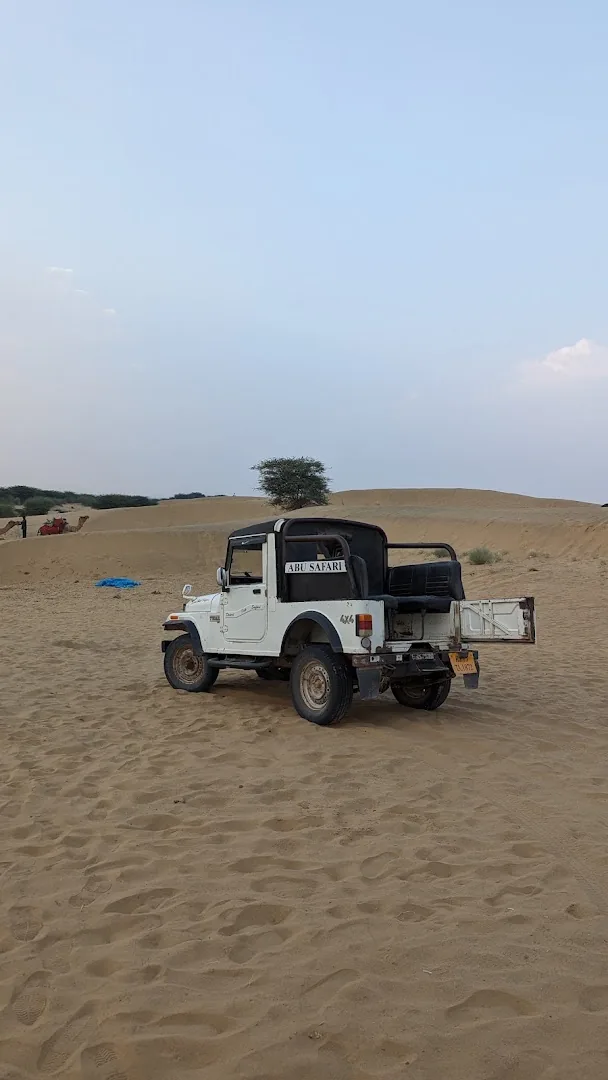A safari jeep parked on the crest of a dune at Sam