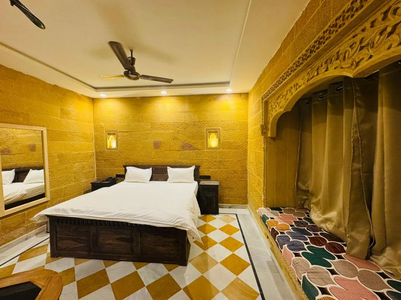 A deluxe room with a wooden bed and a chequered marble floor